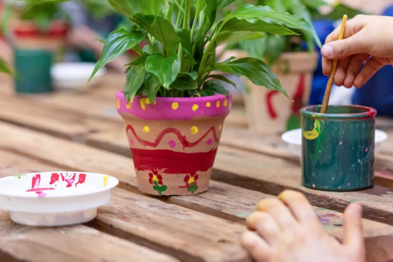 Children are painting potted plants made of pottery
