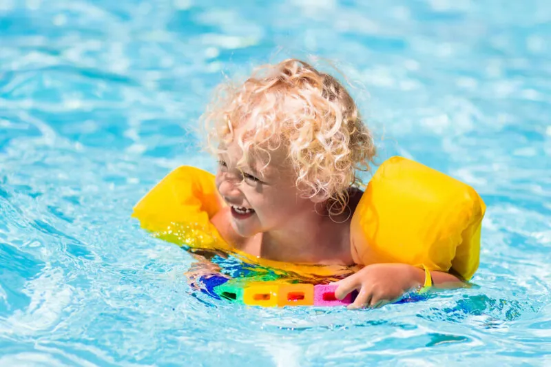 Happy little boy in swimming pool